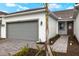 Front exterior view of a single-Gathering home with gray garage door and brick pathway at 12318 Hearts Ease St, Venice, FL 34293