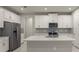 Modern kitchen with white cabinets, stainless steel appliances, and large island at 12318 Hearts Ease St, Venice, FL 34293
