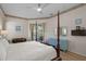 Main bedroom with a post bed, light wood floors, and a view to the pool at 16310 Ashington Park Dr, Tampa, FL 33647