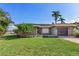 Single-story home with a two-car garage and lush landscaping at 16323 Redington Dr, Redington Beach, FL 33708