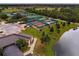 Aerial view of tennis courts and clubhouse near a lake at 324 Caloosa Palms Ct, Sun City Center, FL 33573