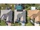 High-angle view of three homes with varying roof colors and pools at 324 Caloosa Palms Ct, Sun City Center, FL 33573