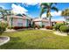 Single story home with pink exterior, teal accents, and mature landscaping at 324 Caloosa Palms Ct, Sun City Center, FL 33573
