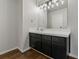 Bathroom with dark vanity, updated lighting, and a large mirror at 394 Ulelah Ave, Palm Harbor, FL 34683