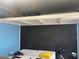 Simple bedroom has chalkboard paint on one wall, loft storage, and is staged with mattress and some personal items at 2716 49Th S St, Gulfport, FL 33707
