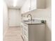 Bright laundry room with white cabinets, granite countertops, and tile floors at 736 Island Way # 606, Clearwater Beach, FL 33767