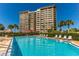 Resort-style pool with lounge chairs and a building view at 736 Island Way # 606, Clearwater Beach, FL 33767
