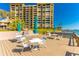 Community patio with tables, chairs, and umbrellas overlooking the water at 736 Island Way # 606, Clearwater Beach, FL 33767