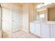 Bathroom with double vanity, white cabinets and a large mirror at 924 Bunker View Dr, Apollo Beach, FL 33572