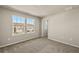 Well-lit bedroom featuring two windows, carpet floors, and access to a hallway at 31496 Woodland Race Loop, Wesley Chapel, FL 33545