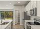 Modern kitchen features white cabinets, stainless steel appliances, and white countertops at 31496 Woodland Race Loop, Wesley Chapel, FL 33545