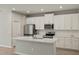 Modern kitchen with white cabinets, quartz countertops, and stainless steel appliances at 31496 Woodland Race Loop, Wesley Chapel, FL 33545