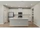 Modern kitchen with white cabinets, quartz countertops, and stainless steel appliances at 31496 Woodland Race Loop, Wesley Chapel, FL 33545