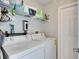 Bright laundry room with washer, dryer, and storage shelves at 31935 Brookstone Dr, Wesley Chapel, FL 33545