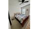 Cozy bedroom with wood framed bed and ceiling fan at 6625 Pebblebrooke Way, Zephyrhills, FL 33541