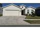 One-story home with light beige siding, a two-car garage, and a brick paver driveway at 6625 Pebblebrooke Way, Zephyrhills, FL 33541