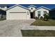 A charming one-story home with a two-car garage and a neatly landscaped front yard at 6625 Pebblebrooke Way, Zephyrhills, FL 33541