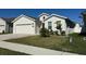 Newly constructed home with light-colored siding, a two-car garage, and a landscaped front yard at 6625 Pebblebrooke Way, Zephyrhills, FL 33541