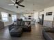 Living room with hardwood floors and grey sectional sofa at 6625 Pebblebrooke Way, Zephyrhills, FL 33541