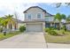Two-story house with gray siding, light blue shutters, and a stone facade at 14319 Italia Dr, Wimauma, FL 33598
