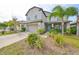 Two-story house with gray siding, light blue shutters, and a stone facade at 14319 Italia Dr, Wimauma, FL 33598