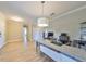 Spacious home office with wood-look floors, large desk, and neutral color palette at 14319 Italia Dr, Wimauma, FL 33598