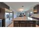 Modern kitchen with dark cabinets, granite island, and stainless steel appliances at 14319 Italia Dr, Wimauma, FL 33598
