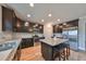 Modern kitchen with dark cabinets, granite island, and stainless steel appliances at 14319 Italia Dr, Wimauma, FL 33598