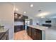 Modern kitchen with dark cabinets, granite island, and stainless steel appliances at 14319 Italia Dr, Wimauma, FL 33598