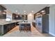 Modern kitchen with dark cabinets, granite island, and stainless steel appliances at 14319 Italia Dr, Wimauma, FL 33598