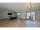 Spacious living room with wood-look tile floors, sliding glass doors, and a view of the backyard at 14319 Italia Dr, Wimauma, FL 33598