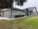 Gray house exterior showcasing a side view with landscaping and driveway at 6554 Gentle Ben Cir, Wesley Chapel, FL 33544