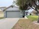 Gray house exterior with a two-car garage and well-manicured lawn at 6554 Gentle Ben Cir, Wesley Chapel, FL 33544