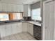 Kitchen features white cabinets, gray countertops and a breakfast bar at 6554 Gentle Ben Cir, Wesley Chapel, FL 33544