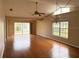Spacious living room with hardwood floors, a ceiling fan, and large windows at 6554 Gentle Ben Cir, Wesley Chapel, FL 33544