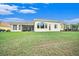 Back exterior view of house with lush lawn and screened patio at 8478 Dunham Station Dr, Tampa, FL 33647