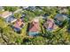 Aerial view showcasing a neighborhood with houses, pools, and lush green trees at 18214 Stillwell Ln, Tampa, FL 33647
