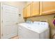 Bright laundry room, washer, dryer, and cabinets at 18214 Stillwell Ln, Tampa, FL 33647
