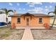 Orange house with a walkway, landscaping, and a detached garage at 440 77Th Ave, St Pete Beach, FL 33706