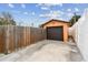 Detached garage with a dark brown door and a wooden fence at 440 77Th Ave, St Pete Beach, FL 33706