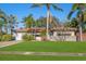 Single story home with red tile roof, lush landscaping, and a large grassy yard at 587 Hillcrest Dr, Largo, FL 33771