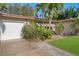 White garage door and lush tropical landscaping at 587 Hillcrest Dr, Largo, FL 33771