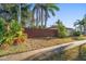 Landscaped side yard with wooden fence and mature trees at 587 Hillcrest Dr, Largo, FL 33771
