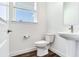 Clean bathroom with white pedestal sink and toilet, dark hardwood floor at 635 115Th Ave, Treasure Island, FL 33706