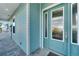 Teal front door with sidelights, enhancing curb appeal at 635 115Th Ave, Treasure Island, FL 33706