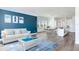 Open concept living room with blue accent wall and white furniture at 635 115Th Ave, Treasure Island, FL 33706