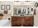 Double vanity bathroom with granite countertops and a soaking tub at 6650 Current Dr, Apollo Beach, FL 33572