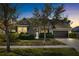 Attractive home exterior at dusk, featuring landscaping and a two-car garage at 6650 Current Dr, Apollo Beach, FL 33572