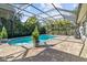 Inviting kidney-shaped pool with screened enclosure, surrounded by a paved patio at 6650 Current Dr, Apollo Beach, FL 33572