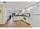 White kitchen cabinets, granite countertops, and wood-look floors at 12000 Gulf Blvd # 309N, Treasure Island, FL 33706